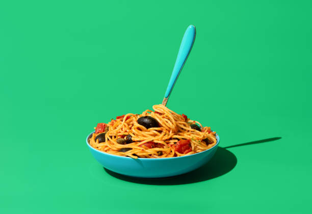 istock Pasta puttanesca dish, minimalist on a green background 1436327058