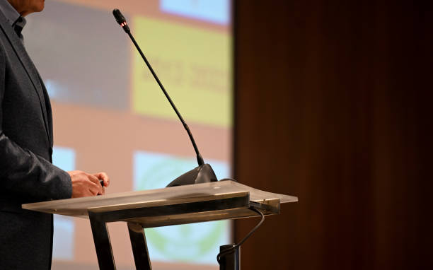 Businessman speaking at conference Businessman at the lectern delivering speech, copy space activist speech stock pictures, royalty-free photos & images