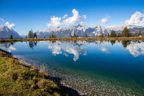 il lago kaltwassersee a seefeld/tirolo. le montagne e le nuvole si riflettono nell'acqua fredda e limpida del lago di montagna - european alps cold mountain range clear sky foto e immagini stock