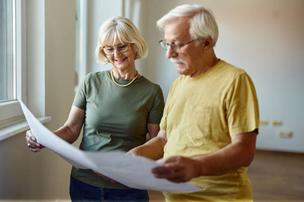 istock Happy mature couple reading blueprints during home renovation process. 1436329076