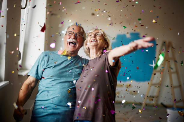 istock Cheerful senior couple among confetti during home renovation process. 1436329519