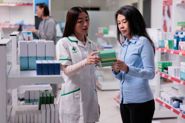 istock Asian pharmacist explaining boxes of pills 1436329758