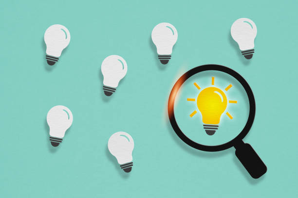 istock idea concept, bright light inside magnifying glass and other white paper cut on grunge green background 1436330755