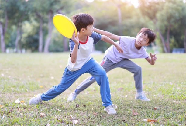 Little boy plays frisbee in park stock photo
