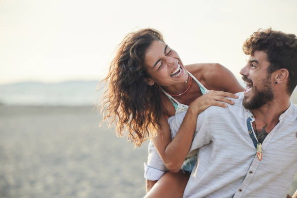 istock Playful couple having fun while piggybacking on the beach. 1436331258