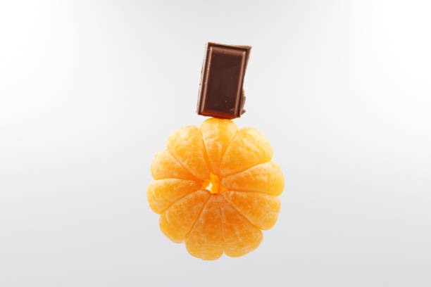 A portion of chocolate on a peeled tangerine