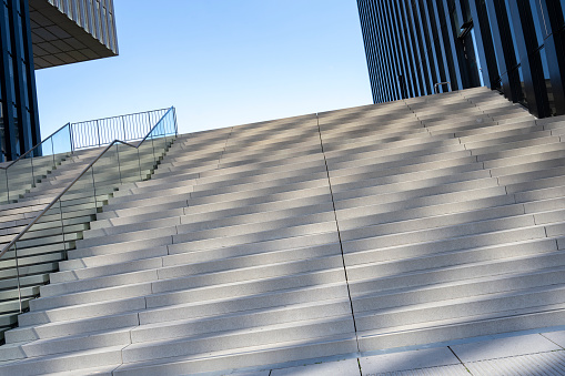 An empty stairway with orange bannister is leading up to the exit of a subway station in Vienna.\nCanon EOS 5D Mark IV, 1/4, f/10, 24 mm.