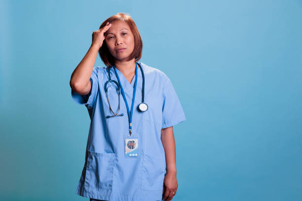 istock Tired physician nurse having migraine while working at disease expertise during checkup visit 1436342452