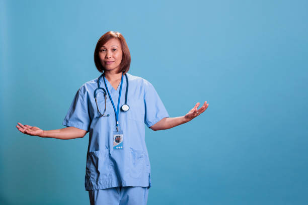 istock Asian elderly nurse doing i don t know gesture in studio with blue background 1436342502