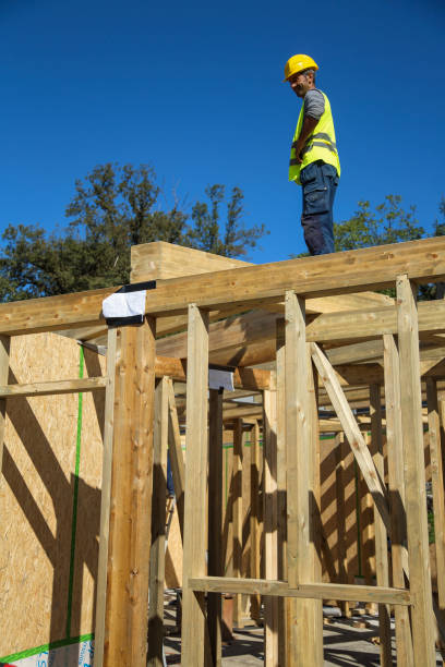 istock Construction worker standing on a wooden house construction site 1436345425