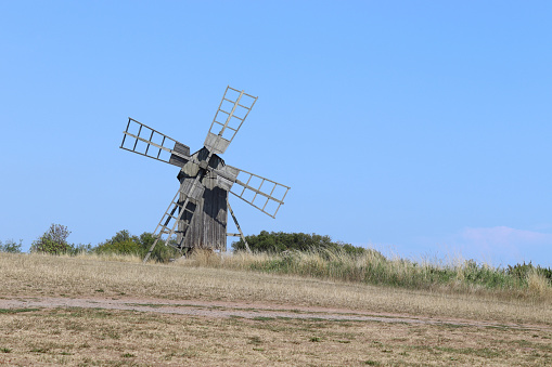 Typical old historic style windmill, found on the island of Öland in Sweden. Against a clear blue sky with copy space.