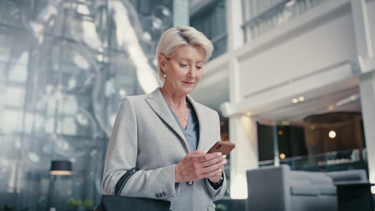 Lobby, smartphone and lawyer business woman using phone for client communication, email feedback or online company update. Wealth, rich and corporate executive walking, typing on cellphone in a hotel