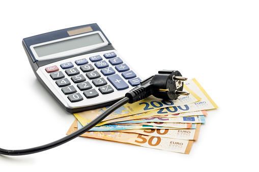 The energy savings concept with electric power plug, calculator  and euro money isolated on the white background.