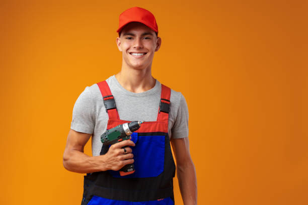istock Handsome young handyman holding screwdriver against yellow background 1436350074