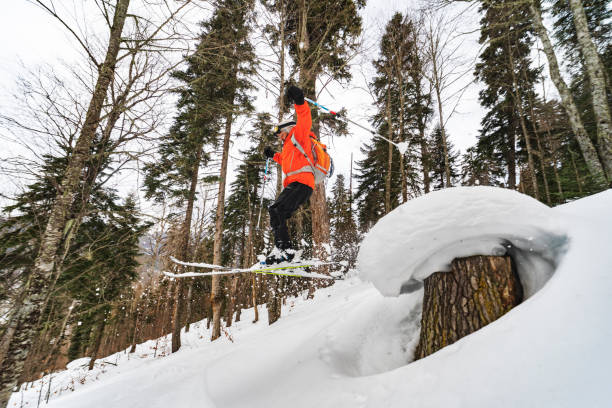 Young adult man skiing in forest