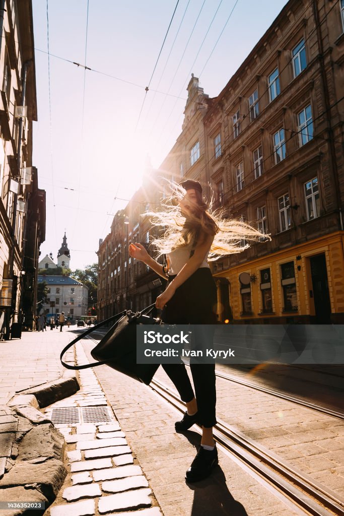 A girl with long hair whirling in the middle of the street on a sunny summer day Dancing Stock Photo