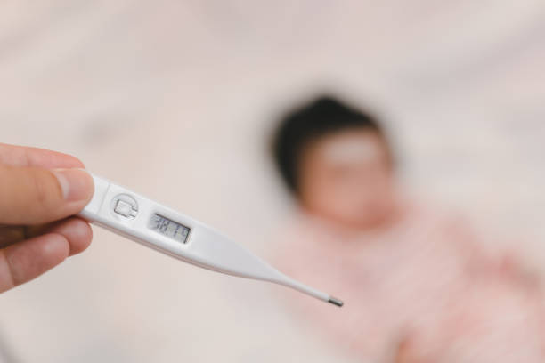 istock Hand with measuring temperature from digital thermometer, Blur sick child background 1436353698