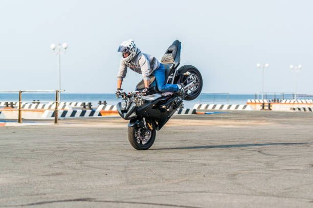 Stunt motorcycle rider performing at the street of the city. stock photo