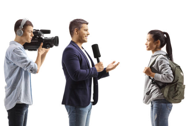 istock Man with a microphone and a cameraman interviewing a female student 1436355164
