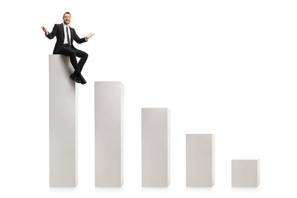 istock Cheerful businessman sitting on a bar chart column and smiling at camera 1436355405