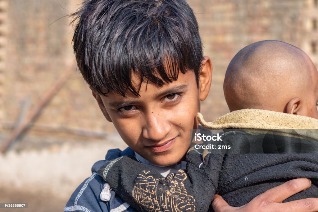 refugee boy refugee boy carrying his new born brother Boys Stock Photo