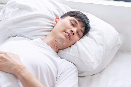 istock Tired asian handsome man sleeping peaceful on white pillow comfortable in morning at apartment white background. Casual asian young male asleep cozy good dream in bedroom. Lifestyle relax concept 1436357305