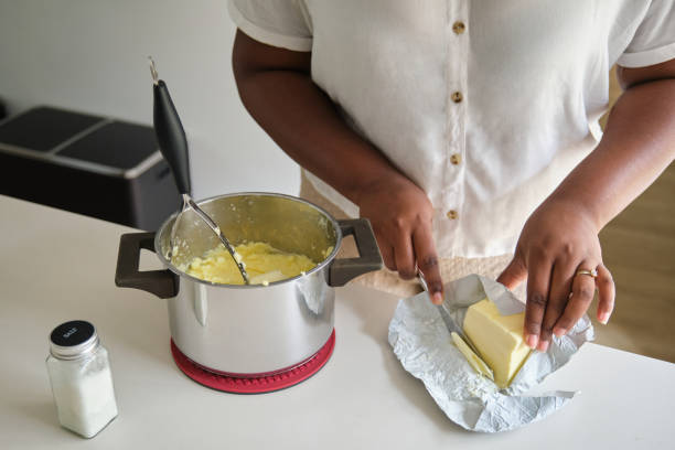 Close up of cuban woman hands adding butter to the mashed potatoes.