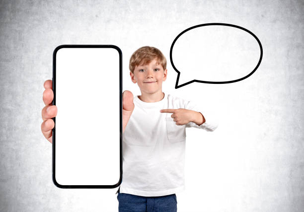 istock Child finger pointing at smartphone big mockup screen on grey background, speech 1436360445