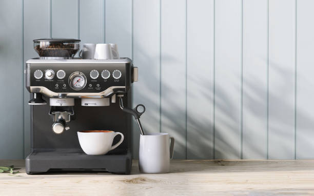 Modern and luxury black espresso maker on wooden counter, coffee cup and sunlight and leaf shadow from window on pastel blue wood panel wall stock photo