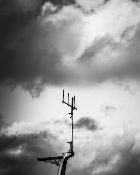 istock Greyscale shot of an antenna with dark clouds background 1436362382