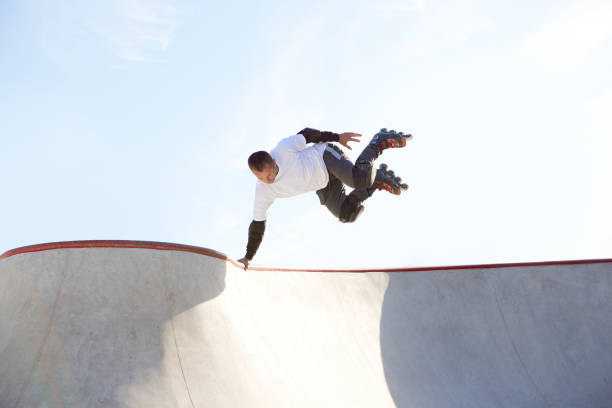 Energetic man on roller skates in motion at modern roller skate park. Professional roller skater doing dangerous and daring tricks. Concept of sport, health, speed, and energy. Leisure time