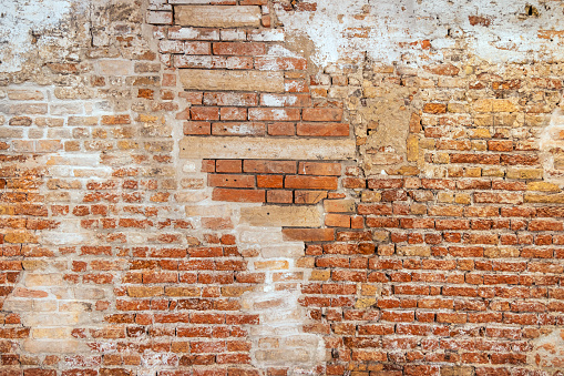 Traces of a walled up window in e old brownstone brick wall in the center of Venice