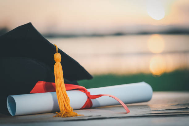 istock A black graduation cap and a certificate placed on wood desk 1436365931