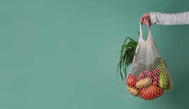 istock Mesh bag with vegetables and herbs in female hand. 1436366401