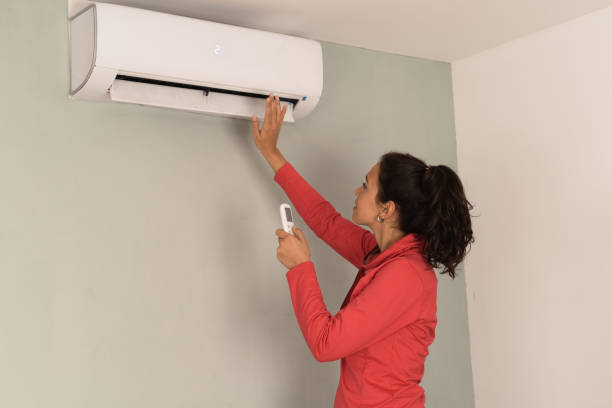 istock Girl turning on air conditioner after moving in 1436368095