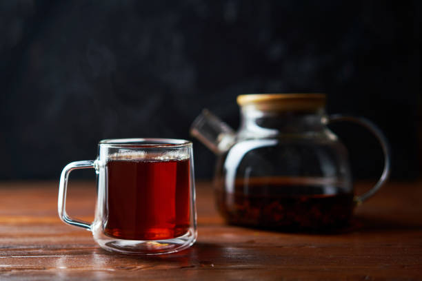 istock Teapot and cup of tea standing on a brown table 1436369158