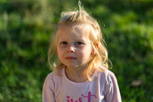 Portrait of cute little blond girl in summer dress.