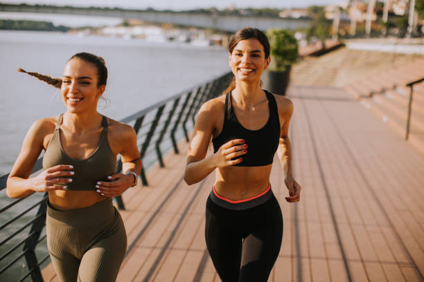 istock Young woman taking running exercise by the river promenade 1436373805