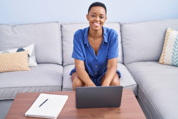 istock African american woman using laptop sitting on sofa at home 1436374448