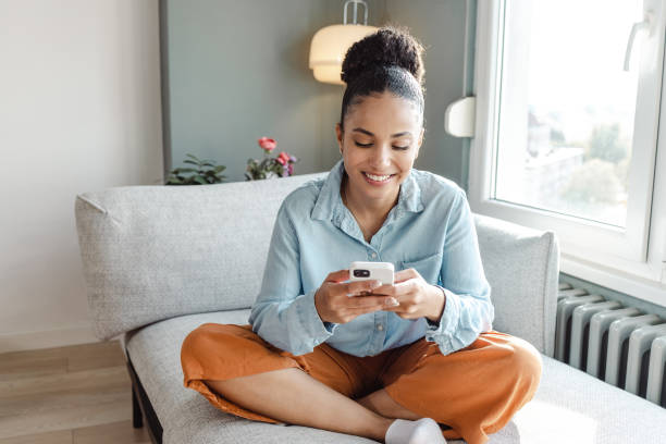 istock A beautiful woman using a smart phone at home 1436376031