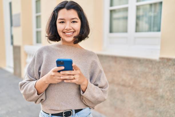 istock Young woman smiling confident using smartphone at street 1436380308