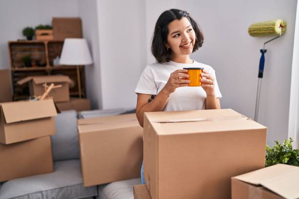 istock Young woman smiling confident drinking coffee at new home 1436380352