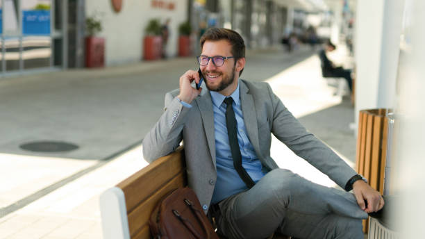istock Businessman talking on the phone while waiting for a train at train station 1436381076