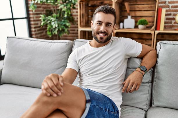 istock Young hispanic man smiling confident sitting on sofa at home 1436381555