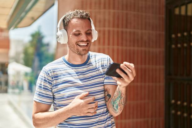 istock Young hispanic man smiling confident watching video on smartphone at street 1436382794