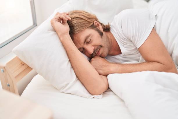 istock Young blond man lying on bed sleeping at bedroom 1436383332