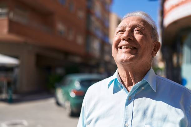 istock Middle age grey-haired man smiling confident looking to the sky at street 1436384065
