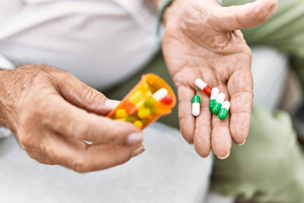 istock Senior man holding pills at home 1436384128