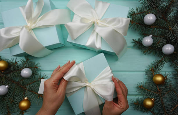 istock Women's hands tie a satin bow on a gift box 1436386629