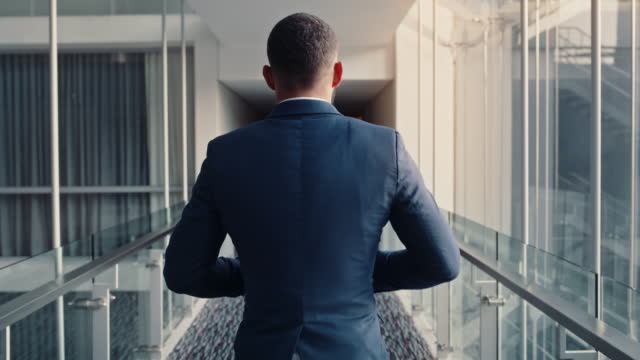 Business man, walking and hallway at office, hotel or conference hall with a successful, confident and professional male inside. Male in suit working as lawyer or corporate person arriving at work